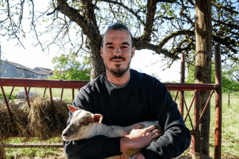 Julien smiling man holding a lamb